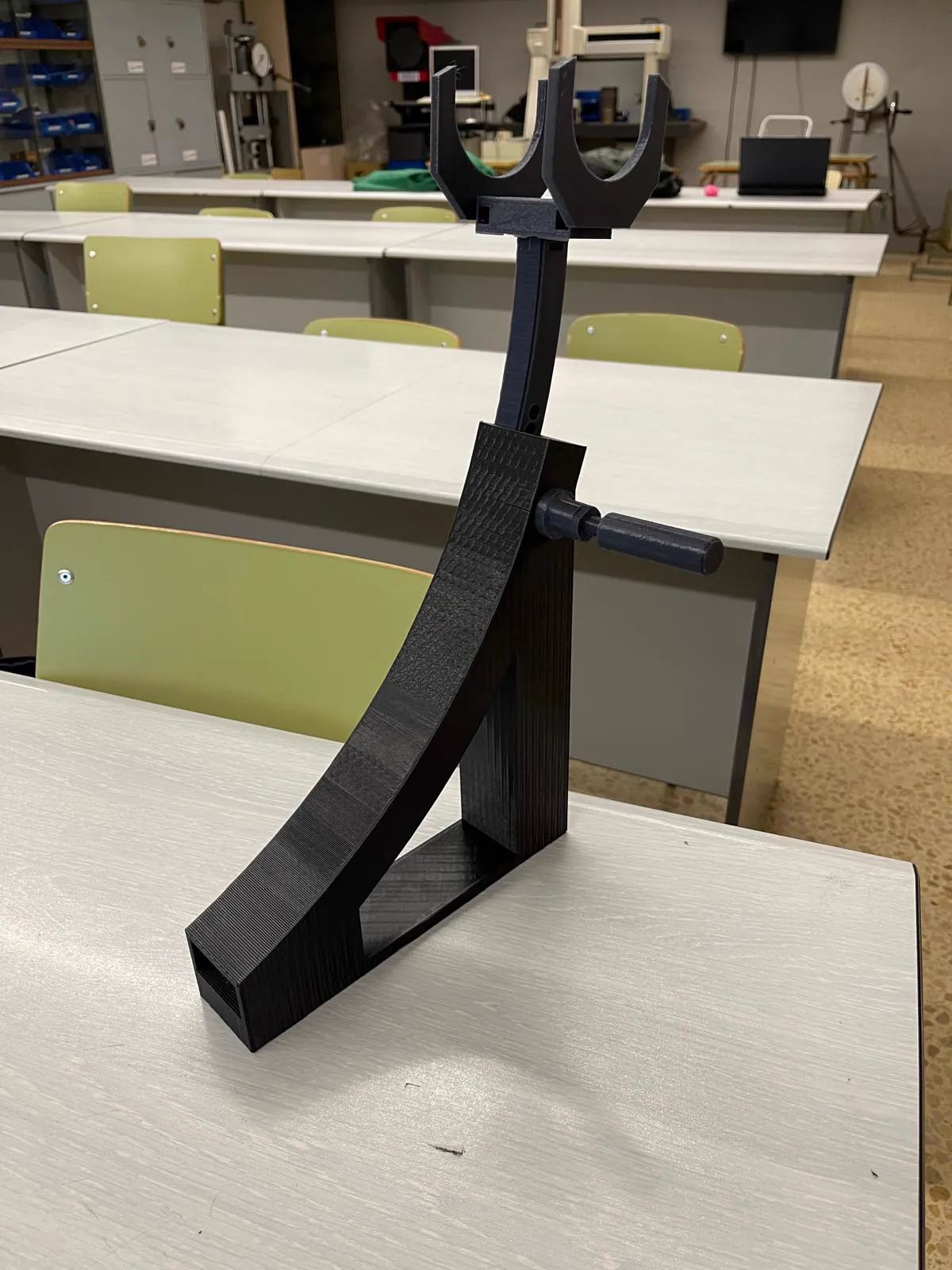 Prototipo negro del soporte sobre una mesa del aula.